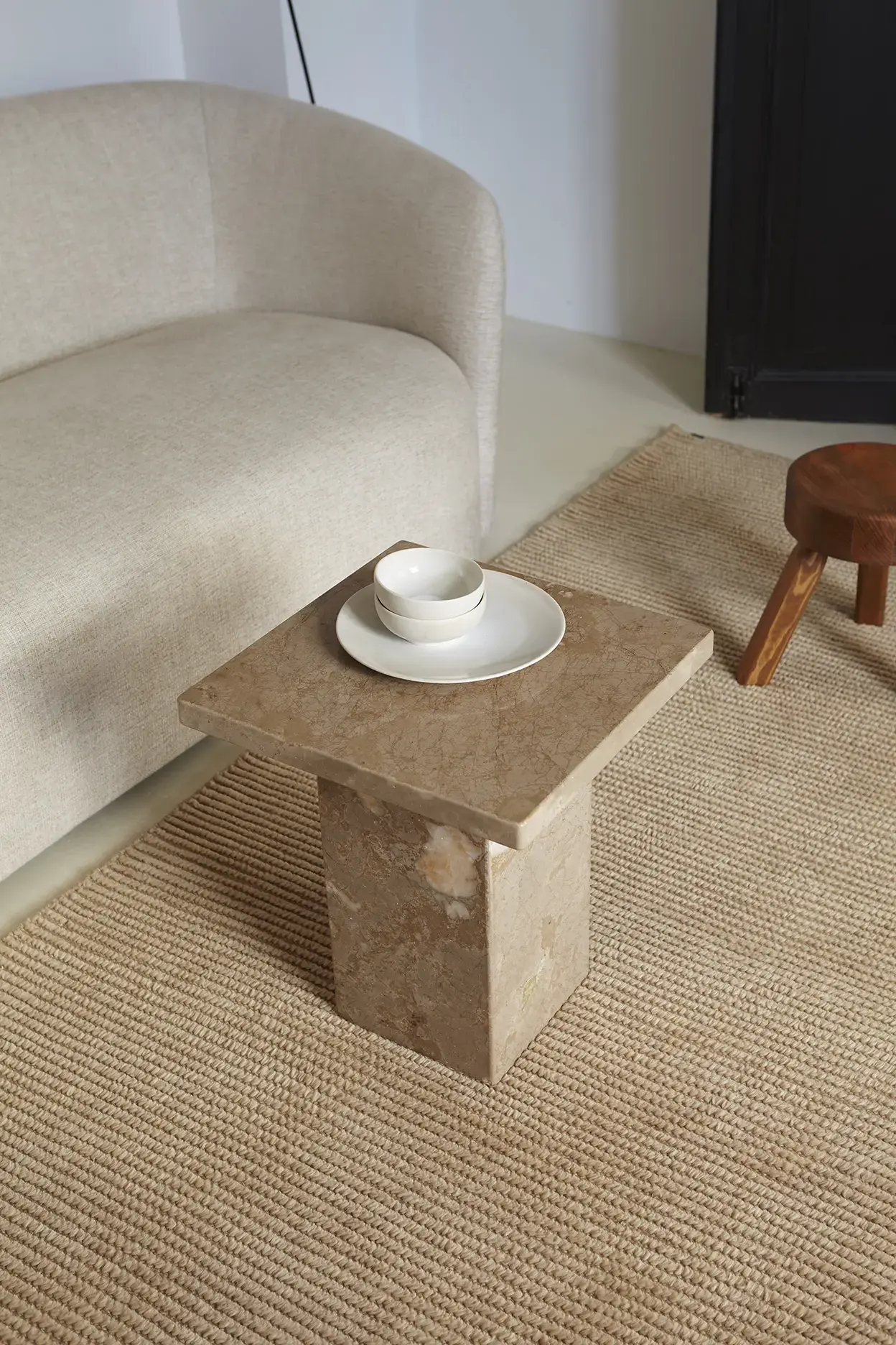 Nami Caramel rug close-up with marble side table and ceramics