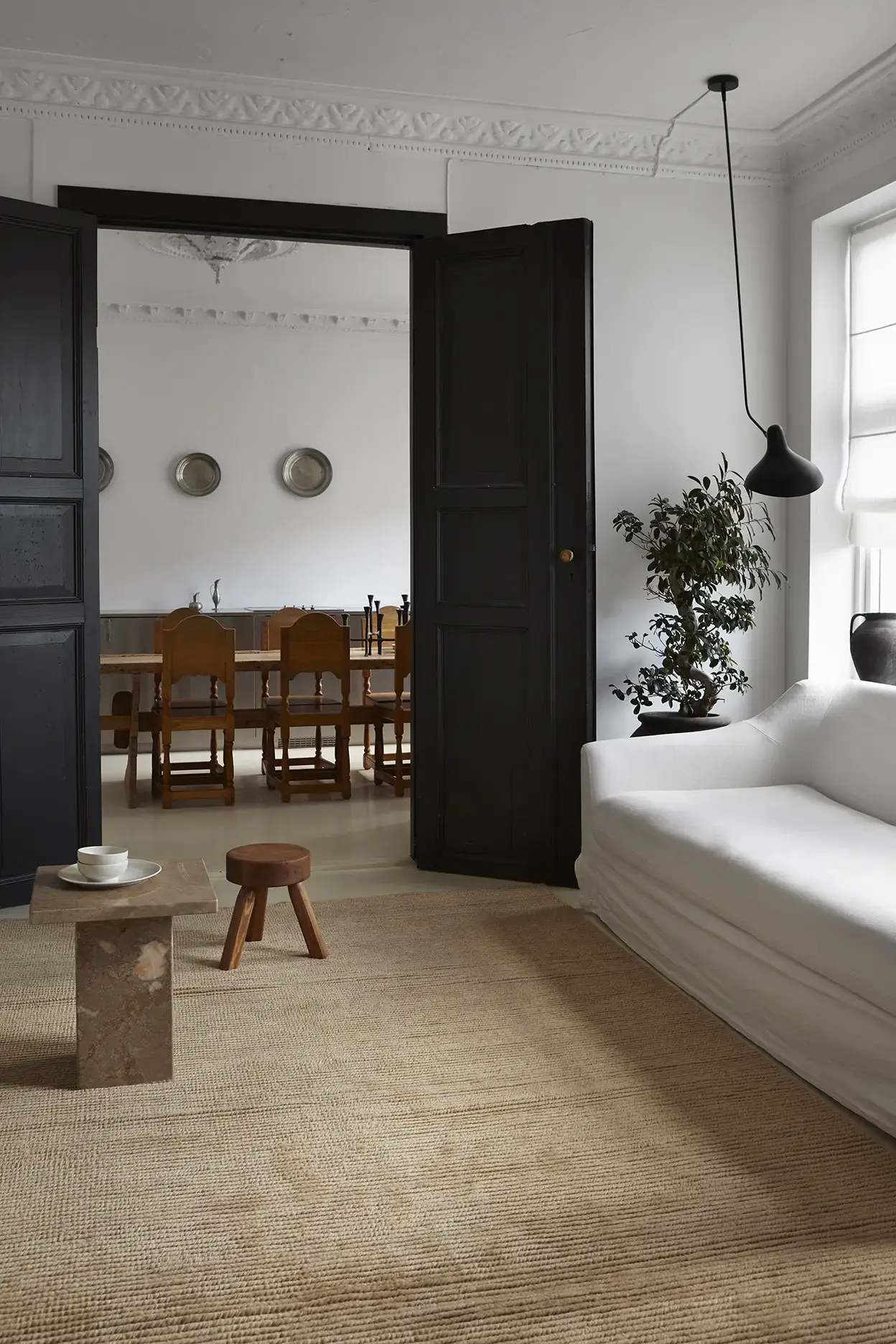 Nami Caramel rug in living room with white sofa and dining room view