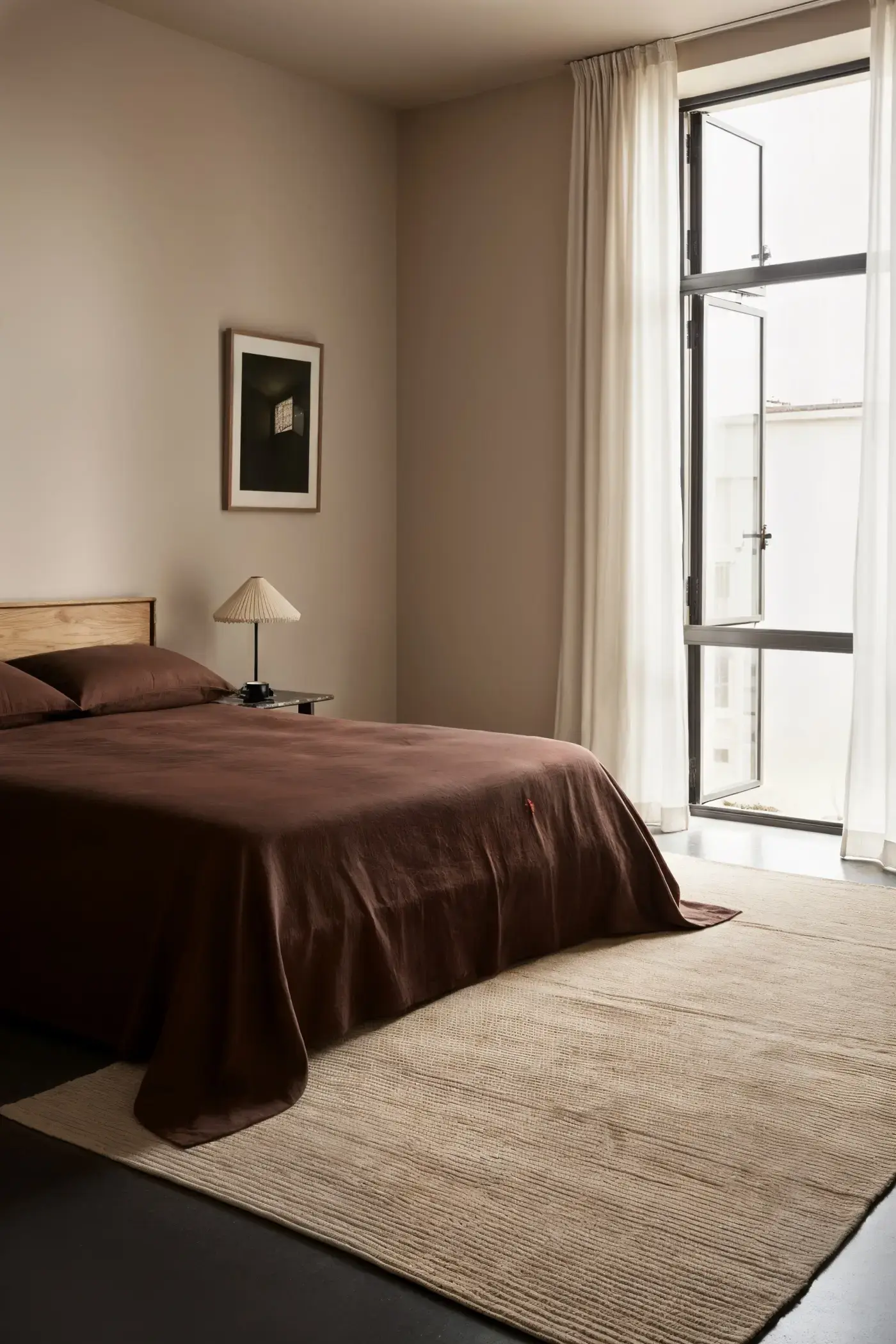 Nami Caramel rug in a minimal bedroom with dark linen bedding