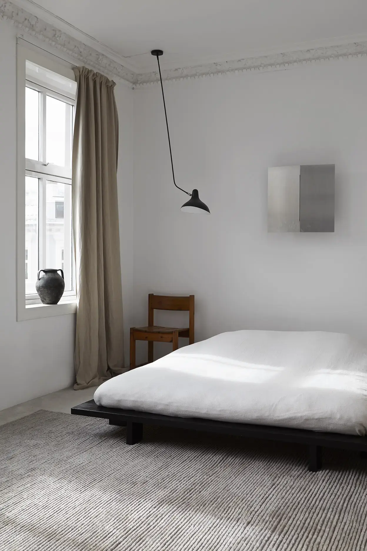 Nami Misty Sky rug in a serene bedroom with platform bed and pendant light