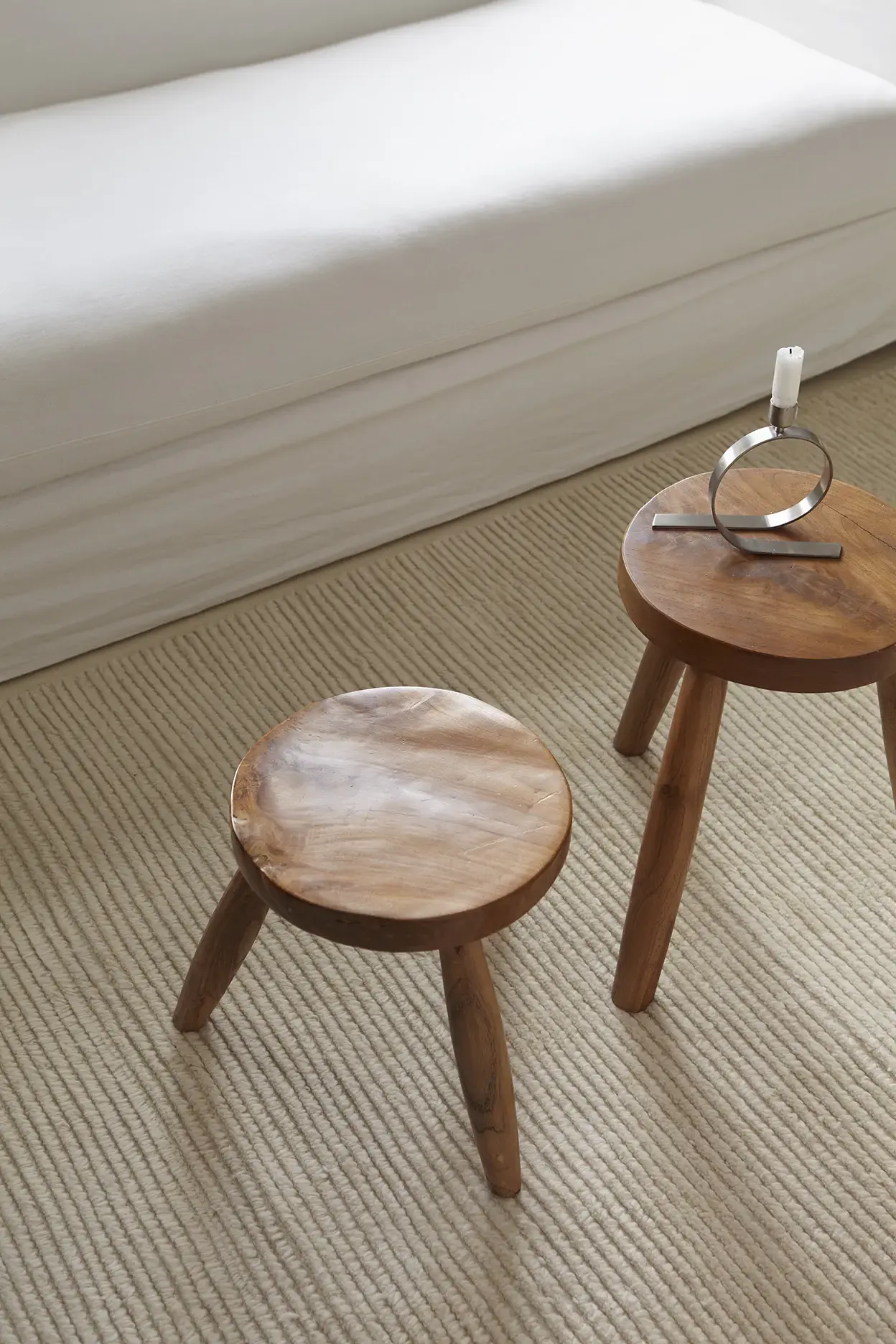 Nami Sand rug texture detail with wooden stools and candle holder