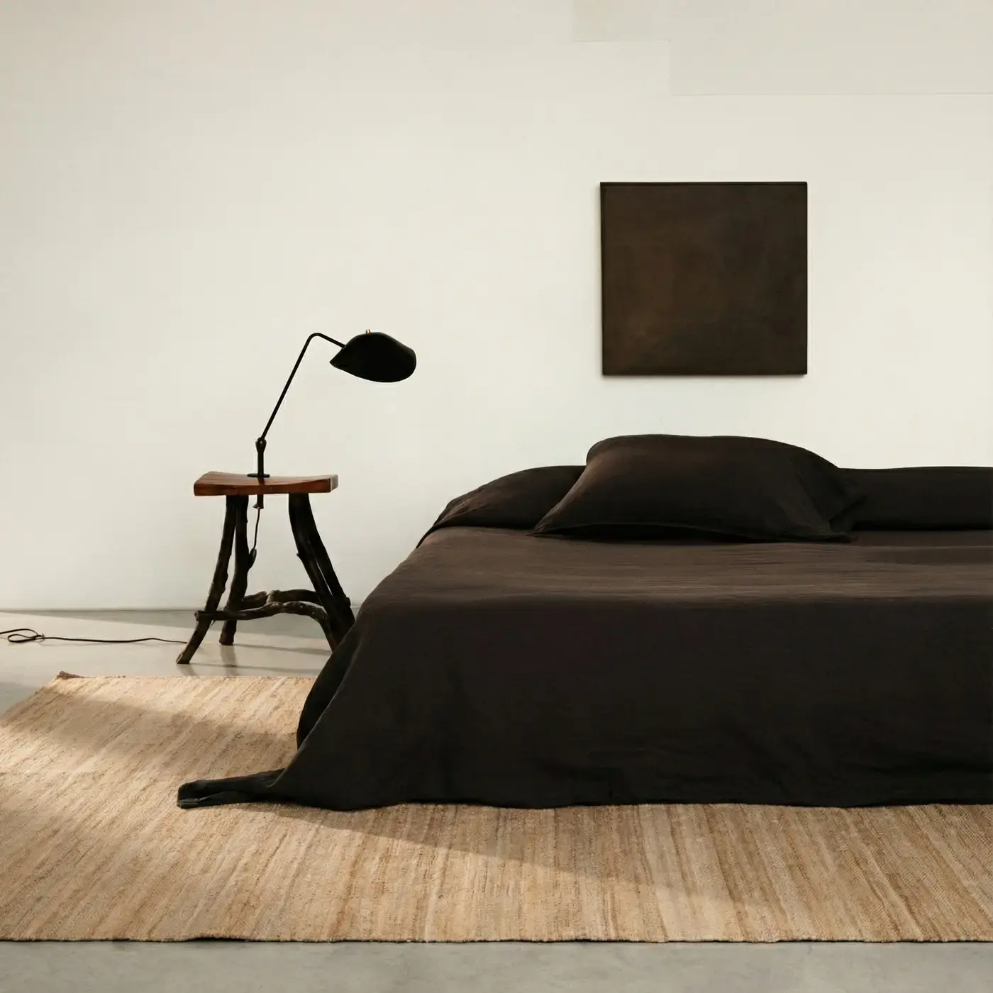 Sabi Natural jute rug in minimal bedroom with dark linen