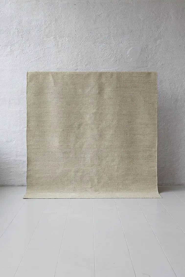 Sabi Sand jute rug displayed hanging against white studio wall