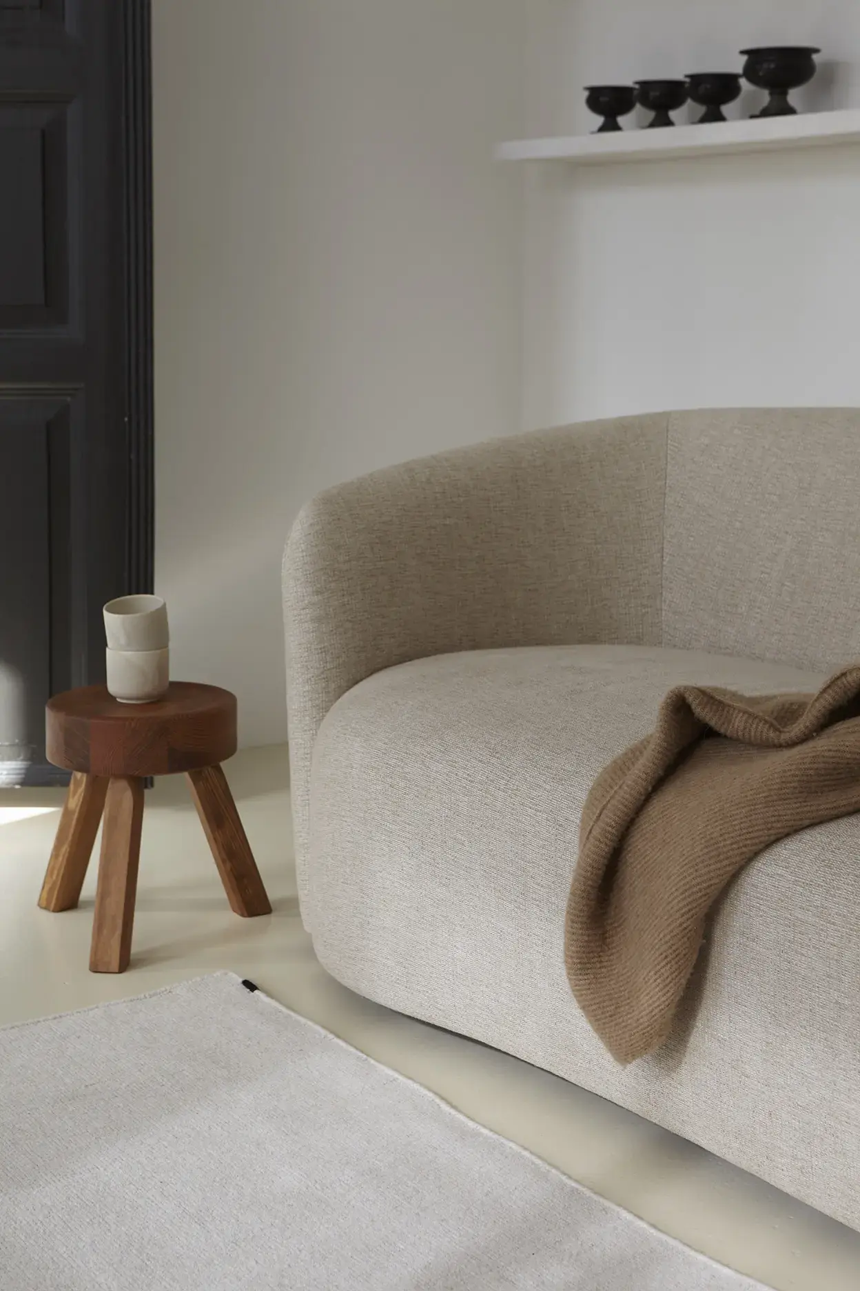 Yuka Clay rug detail with sofa edge and cashmere throw