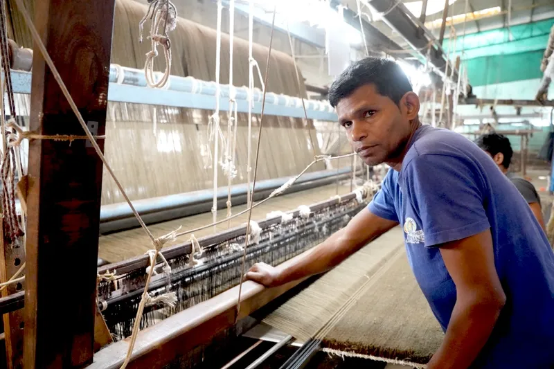 Aman Singh setting up the warp threads on a large-format loom