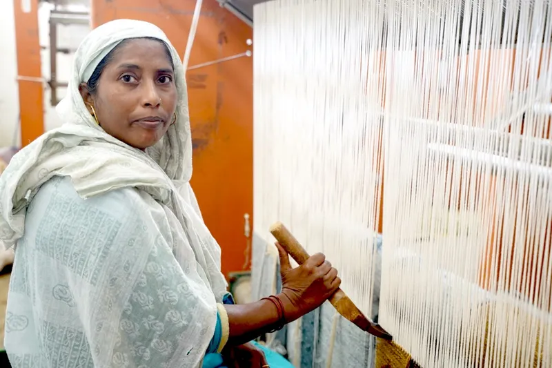 Adult artisan weaving at a loom in a GoodWeave-certified workshop in Bhadohi